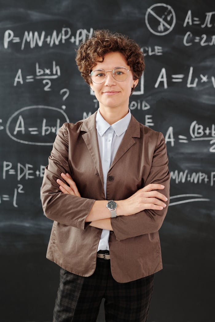 Portrait of a teacher standing in front of a blackboard full of mathematical equations.